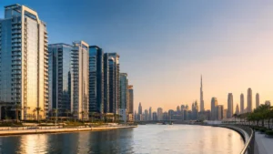 Modern waterfront skyline in Dubai's Business Bay featuring luxury high-rise residential towers, canal views, and the iconic Burj Khalifa at sunset, showcasing why investors choose to buy property in Business Bay.